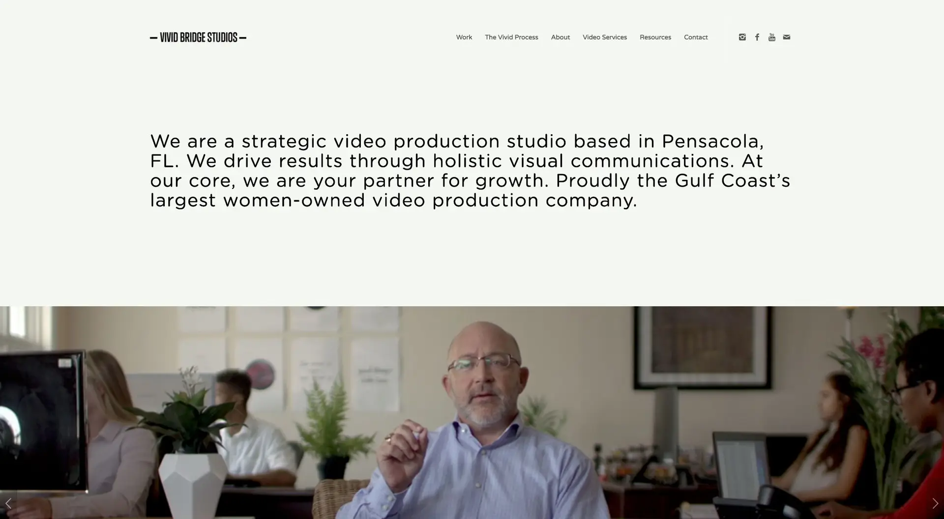 A website homepage of a video production studio, featuring a banner video with a bald man in a shirt speaking, and other employees at work in the background.